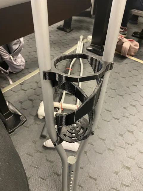 Black printed helical holder clamped between the rails of an aluminium crutch in a lecture hall