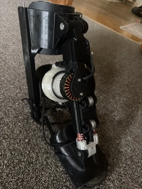Black PLA Kicker standing on its own, motor stator and V-wheels visible