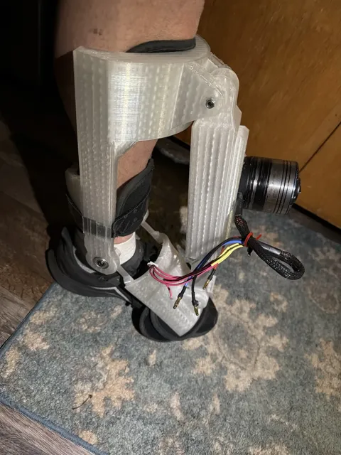 Clear PETG prototype of the Kicker worn on a bare leg over a sneaker
